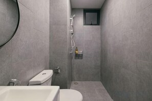 Un baño con inodoro, bidé y zona de ducha.