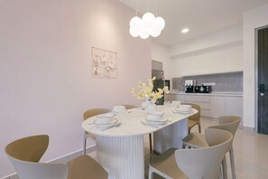 Un comedor moderno con una mesa redonda, sillas y un florero.
