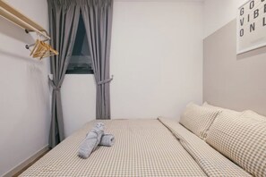 Un dormitorio con cama, cortinas y un cartel en la pared.