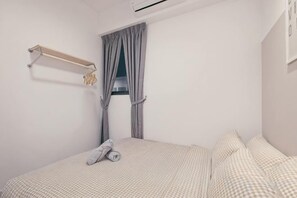 A bedroom with a bed, a window with curtains, a wall-mounted shelf, and a wall-mounted air conditioning unit. - M Vertica Tower A Tower A by FEEL HOME (Kuala Lumpur)