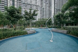 Zona residencial con un camino azul curvo, rodeado de vegetación y edificios altos.