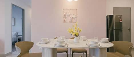 A modern dining area with a round table, chairs, and a decorative light fixture.