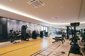 A modern gym with various exercise equipment, a mirrored wall, and a spacious layout. - M Vertica Tower A Tower A by FEEL HOME (Kuala Lumpur)