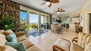A spacious living area with a large sofa, a dining table, and a kitchen in the background. - Na Hale O Keauhou A4 3 Bedroom Condo (Kailua-Kona)