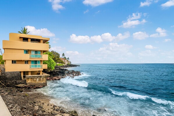 A coastal building with multiple balconies overlooking the ocean.