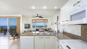 A modern kitchen with a built-in dishwasher, a microwave, and an induction cooktop. - Na Hale O Keauhou G4 3 Bedroom Condo (Kailua-Kona)