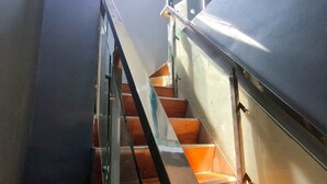 A modern staircase with metal railings and wooden steps.