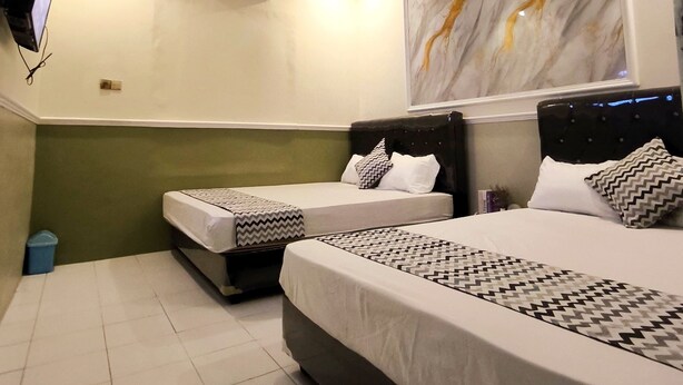 A hotel room with two beds, a flat-screen TV mounted on the wall, an air conditioning unit, and a marble-patterned artwork on the wall.