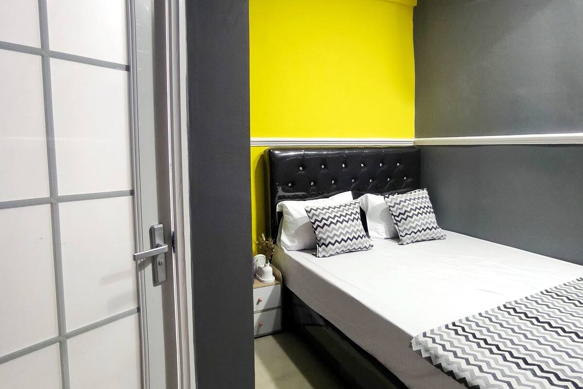 Una camera da letto con un letto, un comodino, un armadio e un condizionatore d'aria a parete.