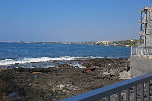 A rocky coastline with a building featuring a balcony. - Alii Villas #224 1 Bedroom Condo (Kailua-Kona)
