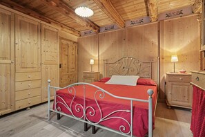 Une pièce en bois avec un lit, une table de chevet et une commode.