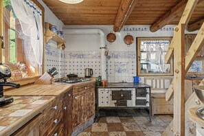 Une cuisine avec des meubles en bois, un fourneau et une fenêtre donnant sur un beau paysage.