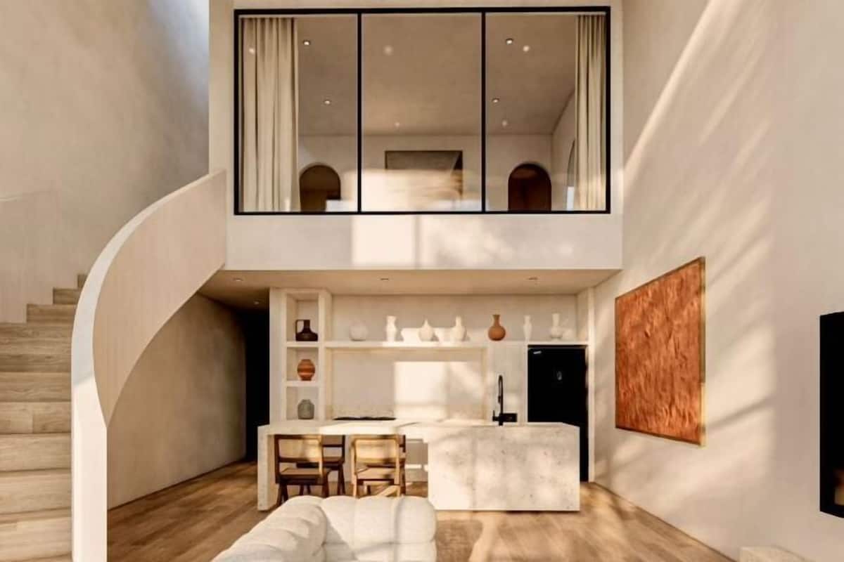 A modern interior with a curved staircase, a dining area, and a kitchen.