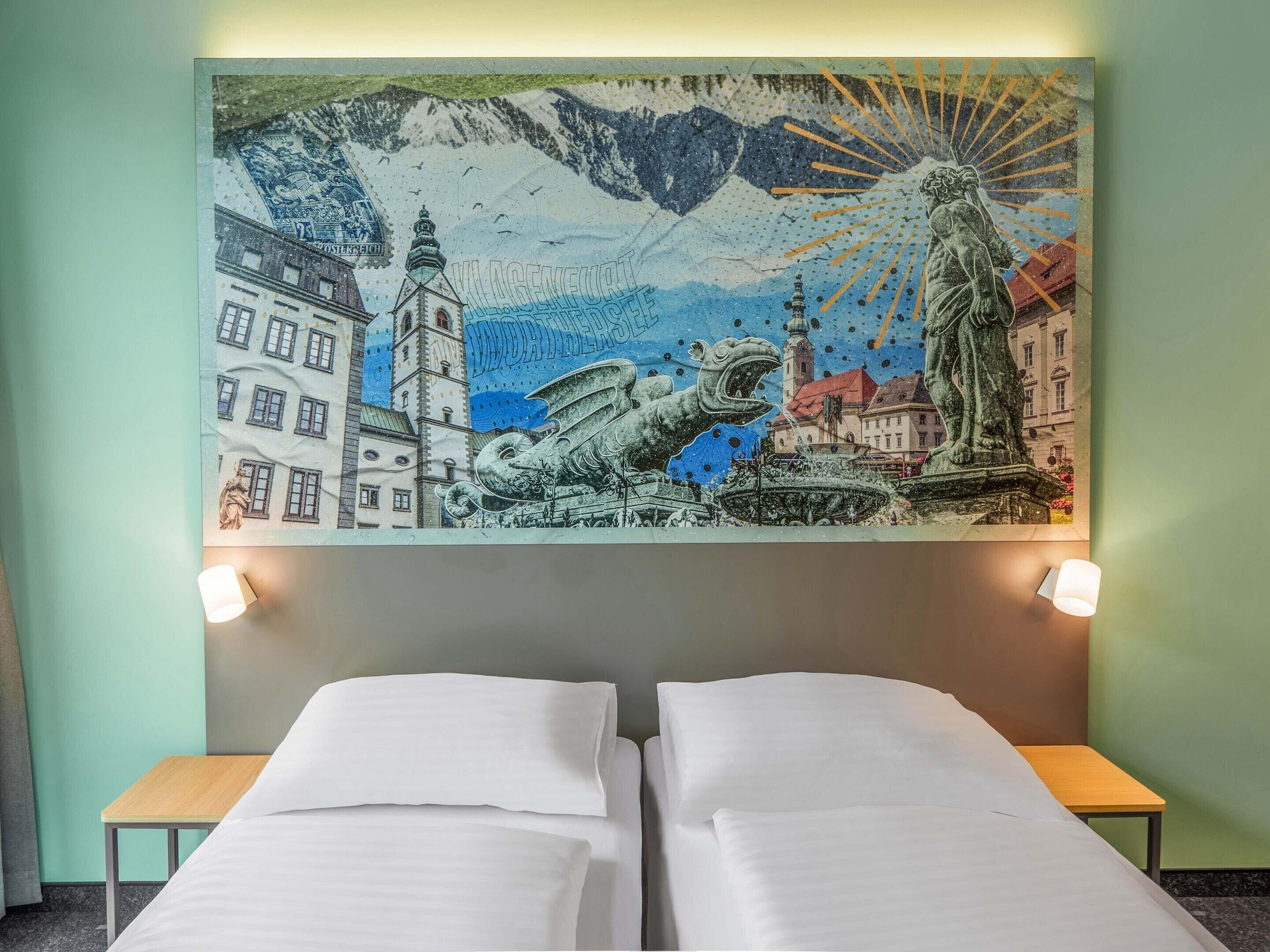 Une chambre d’hôtel avec deux lits, une fresque murale et une petite table.