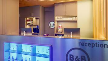 Een receptie met een balie, een robot decoratie, en een presentatie van wijnglazen en flessen.