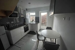 Una cucina compatta con zona pranzo, una finestra e vista all'esterno.