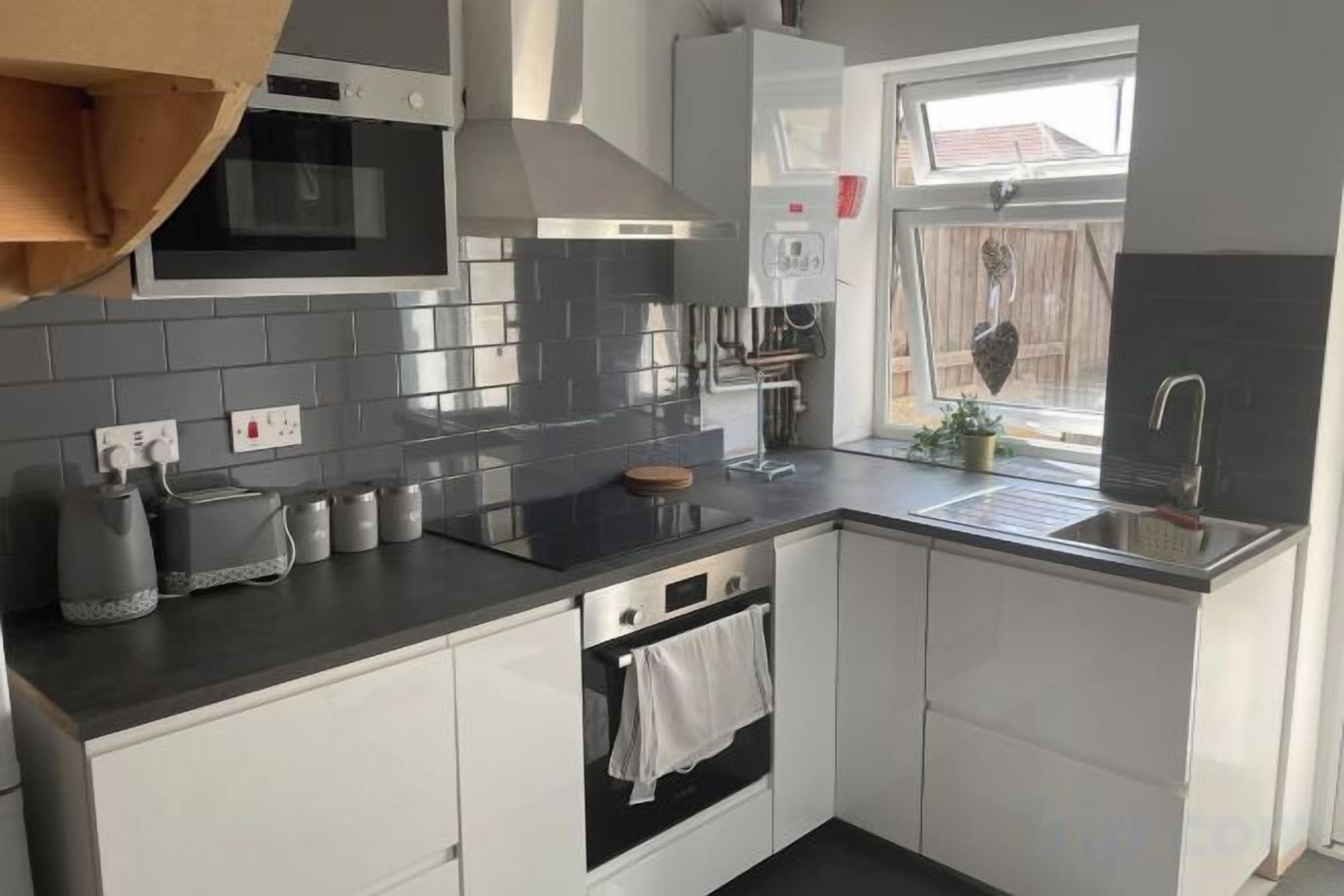 Une cuisine moderne équipée d’un four à micro-ondes, d’une cuisinière et d’un évier.