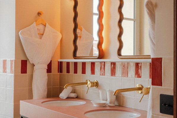 A bathroom with two sinks, a towel rack, a mirror, and a window. - Hotel Posidonia (Nice)