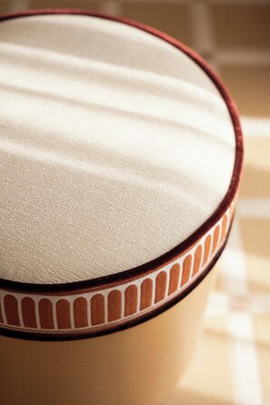 A close-up of a fabric-covered object with a patterned edge.