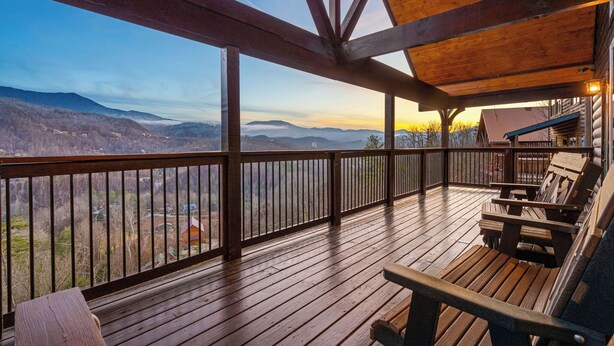 Eine Holzterrasse mit Blick auf ein Tal und Berge.