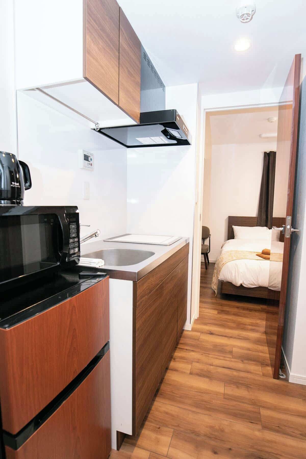 Een koelkast, een microgolfoven, kookgerei, borden en bestek