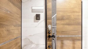 Ett hotellrum med en dörr av trä, en vägg av marmor och en nummerskylt som visar att det är rum 302.