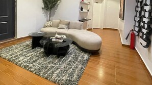 Een moderne woonkamer met een gebogen bank, een salontafel en een potplant.