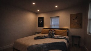 A bedroom with a bed, a window, and a wall-mounted artwork. - Wavecrest Retreat (Near Strip & Beach) (Daytona Beach)