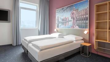 A hotel room with a bed, a nightstand, a painting, a window, and a TV.