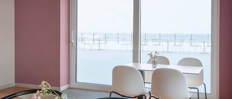 A room with a large sliding glass door leading to a balcony with outdoor seating.