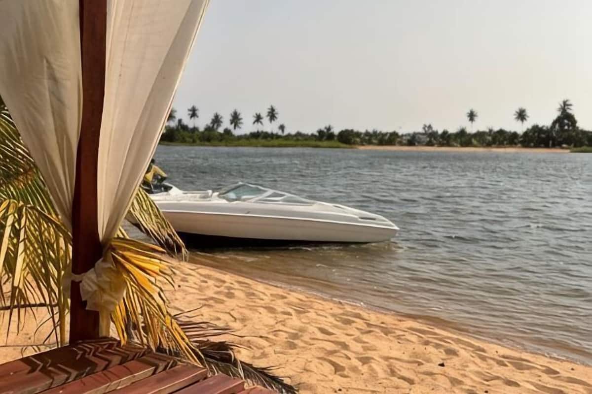 A boat on a sandy beach with a structure in the foreground.