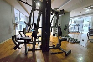 A gym with exercise equipment, a treadmill, and weights. - Studio and 1BR Bassura City City View (Min Stay 3 Nights) (East Jakarta)