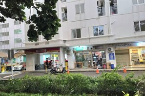 Ein mehrstöckiges Gebäude mit einem Ladenbereich im Erdgeschoss, darunter eine Apotheke und ein Restaurant.