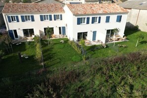 Un bâtiment à deux étages, doté d’un toit plat, d’une cour avant et d’un petit jardin.