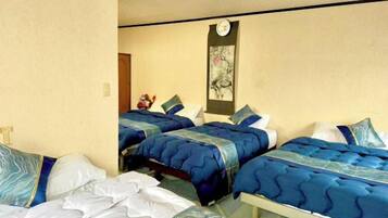 A hotel room with two beds, a small table, and a wall-mounted clock.