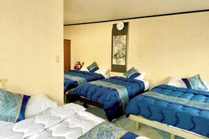 Habitación de hotel con dos camas, una mesita y un reloj en la pared.