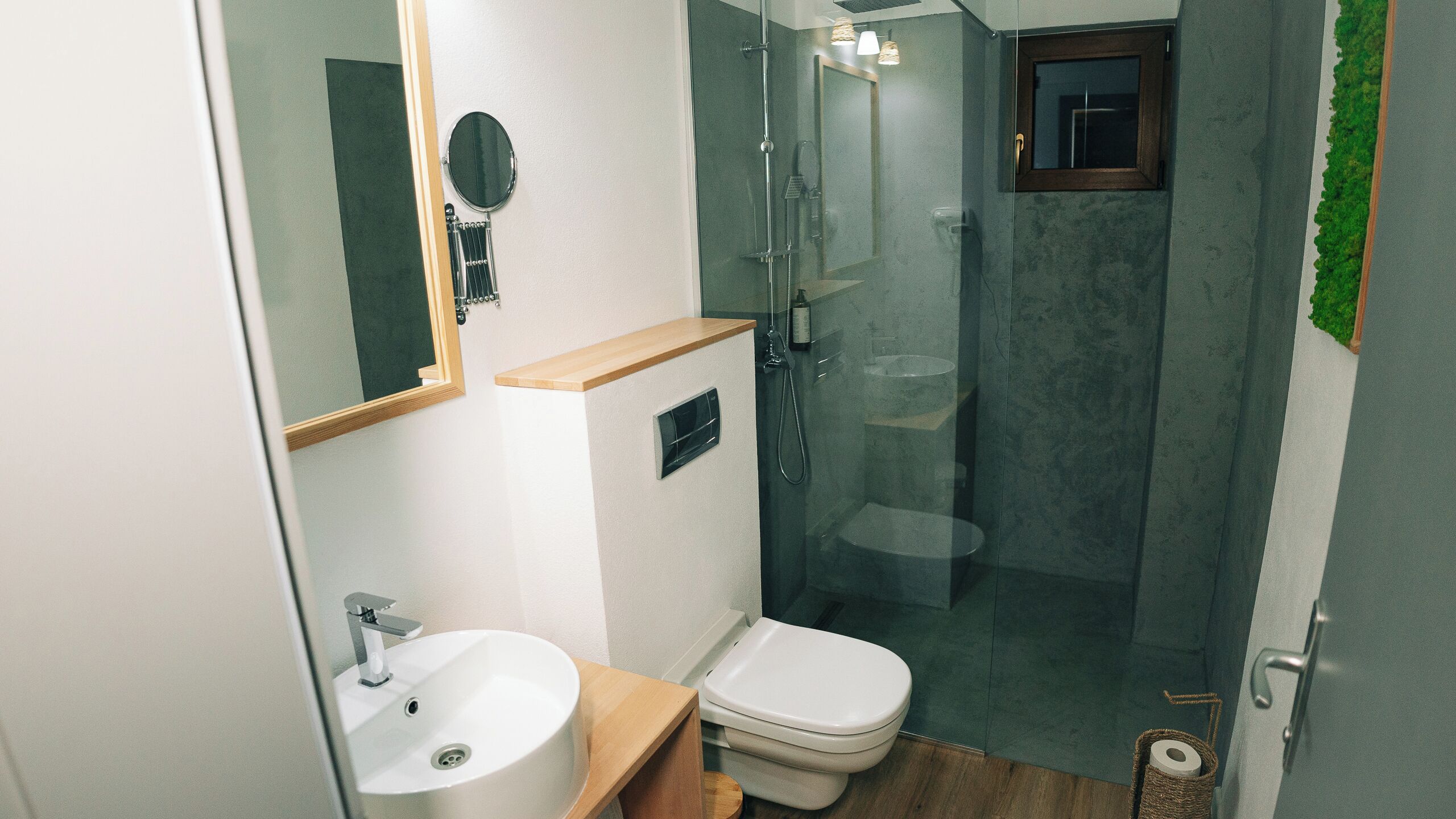 Une salle de bain moderne avec une douche à parois de verre, un lavabo blanc et des toilettes.