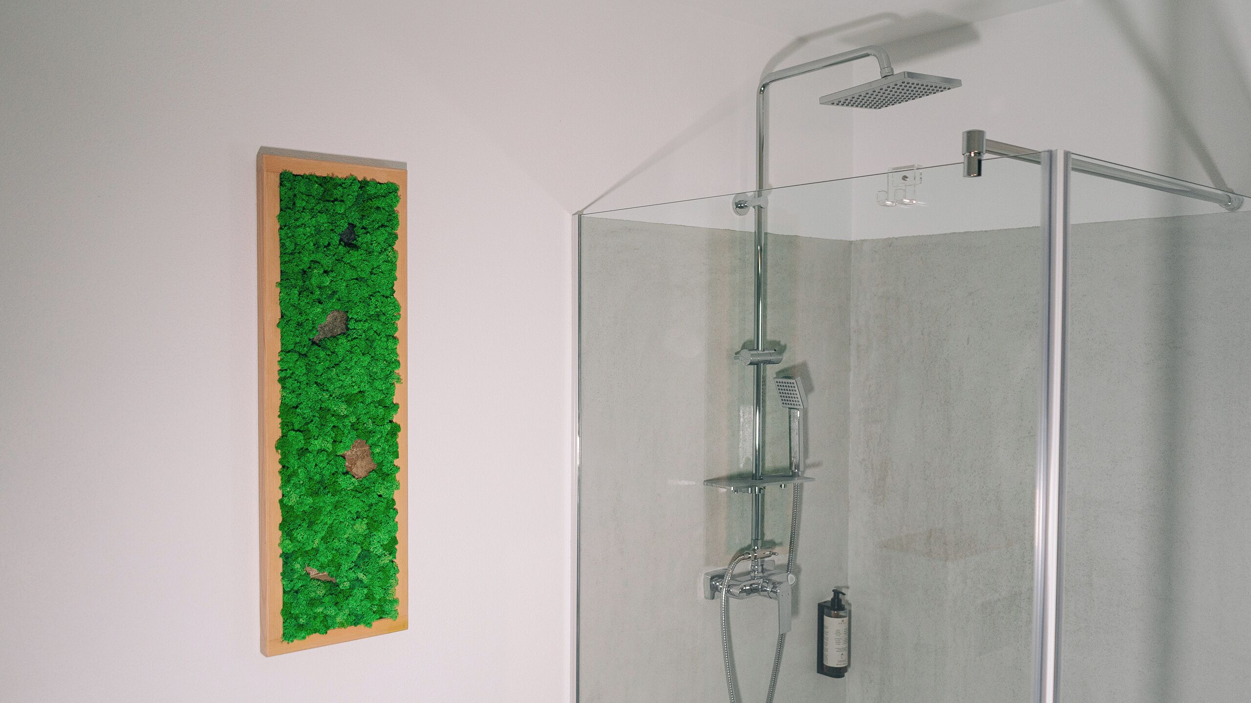 Eine Duschkabine mit Handbrause und wandmontiertem Wasserhahn.