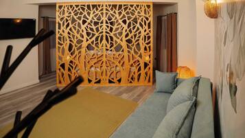 A modern living room with a wooden decorative partition, a sofa with cushions, and a yellow rug.