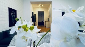 Un interior moderno con una pared de ladrillo blanco, un sofá y un pasillo que conduce a una zona de cocina.