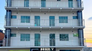 A multi-story hotel with a prominent "HOTEL IDEAL" sign, a glass storefront, and a car parked in front. - Hotel Ideal 5  (Araguaína)
