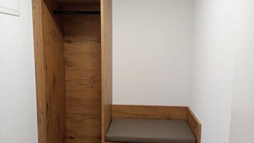 A corner room with a wooden bench and a built-in bench with a cushion.