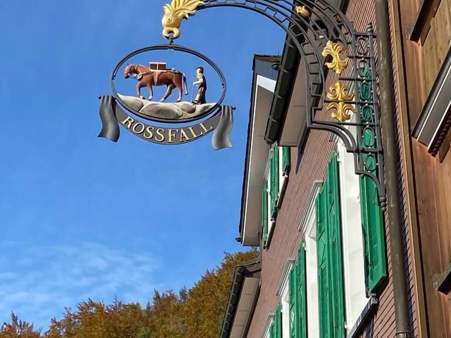 A building with a sign reading "ROSSFALL" featuring a horse and rider emblem.