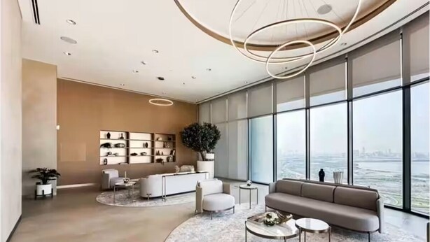 Ein modernes Wohnzimmer mit großem Fenster, einer Couch, einem Couchtisch und minimalistischer Einrichtung.