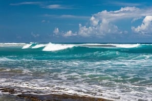 Une plage avec des vagues et un ciel dégagé.