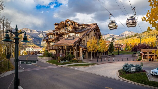 A large, multi-story building with a ski lift cable car system.