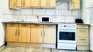 A kitchen with wooden cabinets, a microwave, and a stove.
