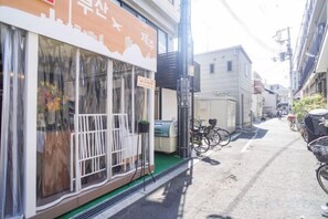 Une rue étroite avec un immeuble doté d’une grande fenêtre et d’une enseigne.