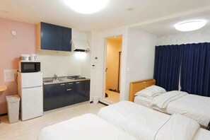 Una habitación de hotel con kitchenette, cama y baño.