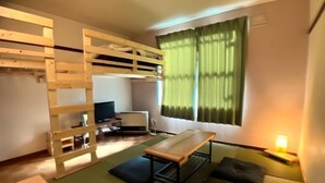 A compact room with a bunk bed, a small table, and a sofa. - City Yugawa Room D (Hakodate)